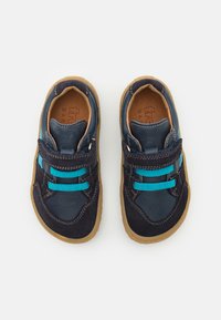 Scarpe blu e navy con una combinazione di pelle e suede, dotate di lacci elasticizzati e suola in gomma. Fodera interna color marrone chiaro.