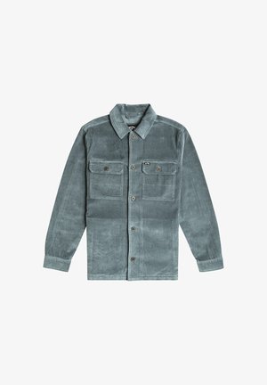 Corduroy jas in gedempt teal, met een klassieke kraag, twee borstzakken, knoopsluiting en zichtbare ribbelstructuur.