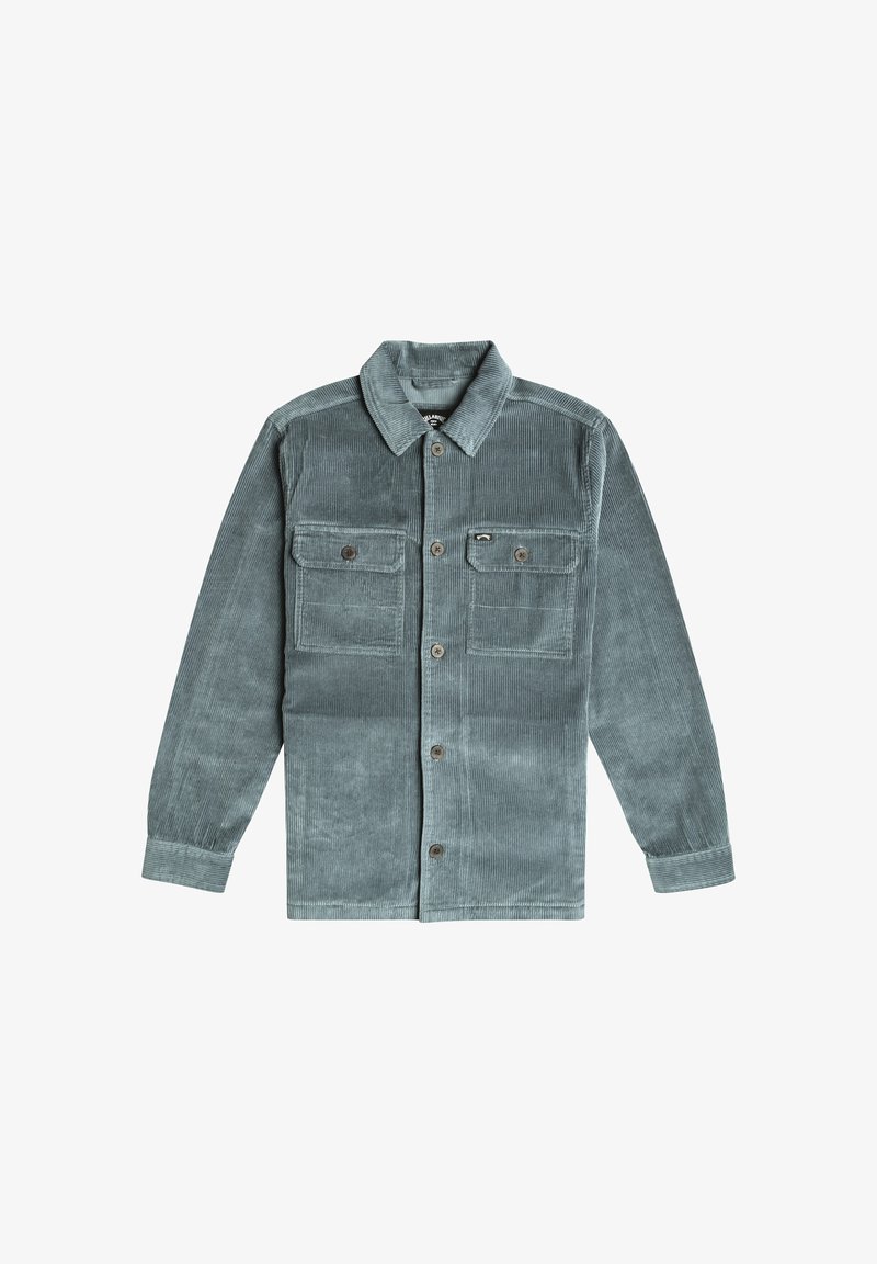 Giacca di velluto a coste in teal smorzato, caratterizzata da un colletto classico, due tasche sul petto, chiusura con bottoni e una texture a coste visibile.