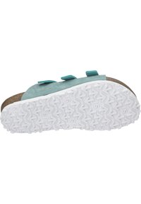 Turkusowa zamszowa sandałka z regulowanymi paskami, korkową wkładką i białą gumową podeszwą z wzorem w zygzak.