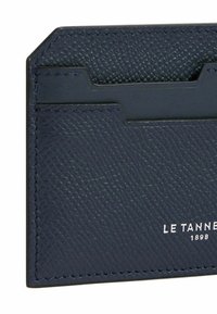 Portafoglio in pelle blu navale con superficie testurizzata, due tasche per carte e marchio in rilievo bianco. Bordo pulito e dettaglio di cucitura a contrasto.