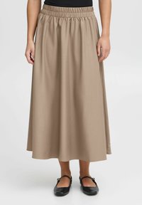 Mid-length beige skirt with an elastic waistband, smooth fabric texture, and flowing design; worn with black flat shoes.