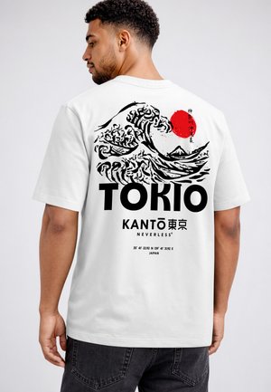 Mann trägt weißes Hemd mit schwarzem und rotem Grafikdesign einer Meereswelle, roter Sonne, dem Berg Fuji und dem Text „TOKIO KANTŌ NEVERLESS“ auf dem Rücken.