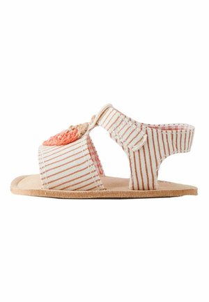 Offener Kindersandale mit beige-weißen Streifen, verstellbarem Knöchelriemen und einer korallenfarbenen Häkelblume auf dem Vorderriemen.