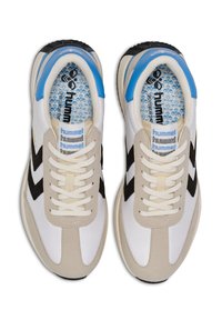 Vita och beige sportskor med svarta chevronaccenter, texturerad yta, rund tå, krämfärgade skosnören och blå häldekoration.