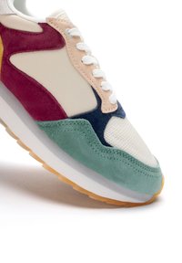 Multikleuren sneaker met groene suède, bordeaux, gele en navy accenten, mesh panelen en een getextureerde rubberen zool.
