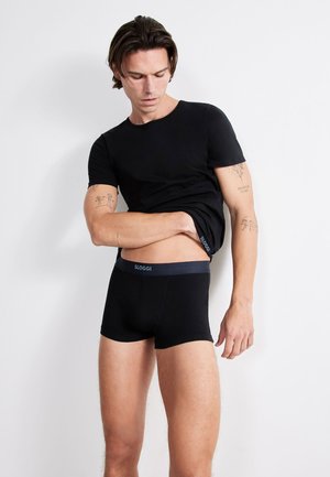 Black SLOGGI boxer shorts with a dark elastic waistband and matching fitted black t-shirt, both made from a smooth, stretchy material.
