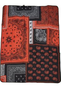Lappet tæppe med sort og rød bandana design med paisley mønstre, glat tekstur og kontrasterende hvide accenter.