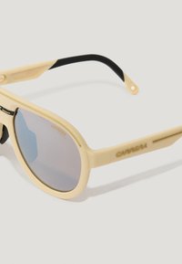 Gafas de sol Carrera con montura de color beige claro, lentes gris espejo y acentos negros en las patillas, fabricadas con un material duradero.