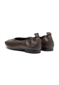 Braune LederBallettschuhe mit runder Zehenform, weichem Material und kleinem Absatz. Die Rückseite hat ein gerafftes Design mit Zugschlaufe für ein einfaches Anziehen.