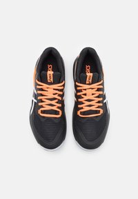 Une paire de chaussures de course Asics noires et blanches avec des lacets et un logo orange vif, vues de dessus sur un fond blanc.