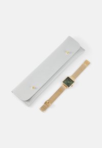 Montre à bracelet en maille dorée avec un cadran rectangulaire vert, accompagnée d'un étui en cuir gris clair avec un fermoir à pression doré.