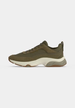 Sneaker verde oliva con suola spessa bianca e marrone, tomaia in mesh e scamosciato, lacci e logo Michael Kors sul lato.
