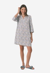 Abito a maniche corte, lungo fino al ginocchio, in tessuto leggero con motivo floreale paisley in viola e blu su sfondo bianco.