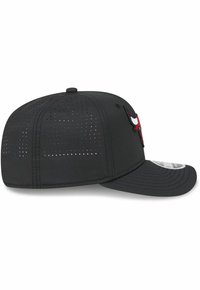 Gorra de béisbol negra con visera curva, que presenta un logotipo bordado en rojo y blanco en la parte delantera y detalles perforados en los laterales.