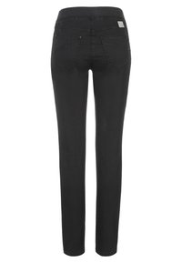 Jean en denim noir avec une coupe slim, comprenant des poches arrière standard et une ceinture cousue. Texture lisse avec un minimalisme dans les détails.