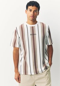 Striped short-sleeve t-shirt in white, brown, and black. Features ribbed texture and "ROMA" embroidered on chest. Relaxed fit.