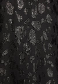 Tissu noir avec un motif d'impression animale gris foncé texturé, irrégulier et réparti uniformément sur la surface.
