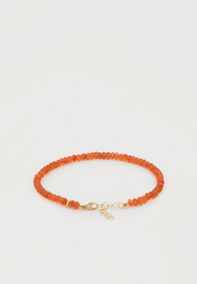 Ελαστικό βραχιόλι με μικρές γωνιακές πορτοκαλί χάντρες και χρυσό κούμπωμα με ρυθμιζόμενο αλυσίδα.