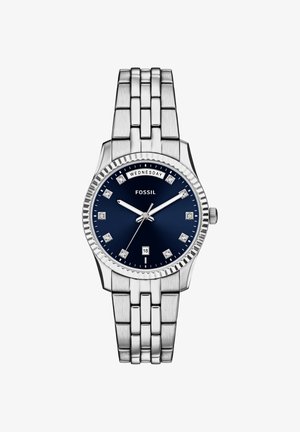 Orologio in acciaio inossidabile argentato con quadrante blu, indici orari simili a diamanti e datario. Caratterizzato da un bracciale a maglie e una lunetta zigrinata.