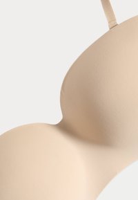 Naadloze bh met een gladde, gevormde pasvorm, verstelbare schouderbanden en een matte textuur zonder zichtbare hardware of patronen.