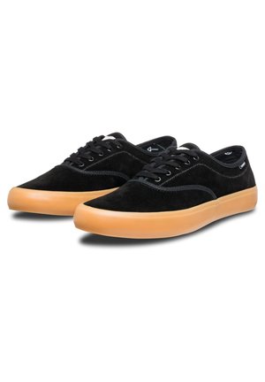 Black suede sneakers with a low-top design, featuring a gum rubber sole, black laces, and contrasting stitching accents.
