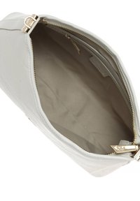 Borsa a mano grigia chiara con una texture trapuntata, zip dorata e un interno vuoto con una fodera beige e un'etichetta di marca.