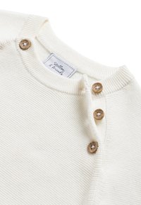 Maglione in cotone color crema con scollatura rotonda, quattro bottoni in legno sulla spalla e un motivo a coste testurizzato.