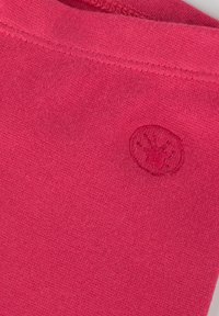 Tessuto di cotone rosa con una finitura testurizzata. Presenta un piccolo logo ricamato di forma circolare sul lato.
