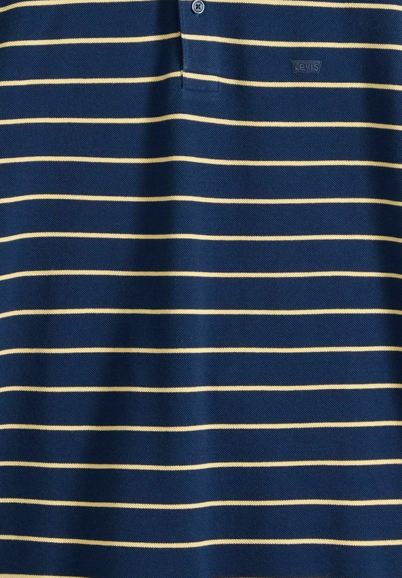 Marineblå polo-shirt med tynde beige horisontale striber og et lille Levi's-logo på venstre bryst, med en knappet krave.