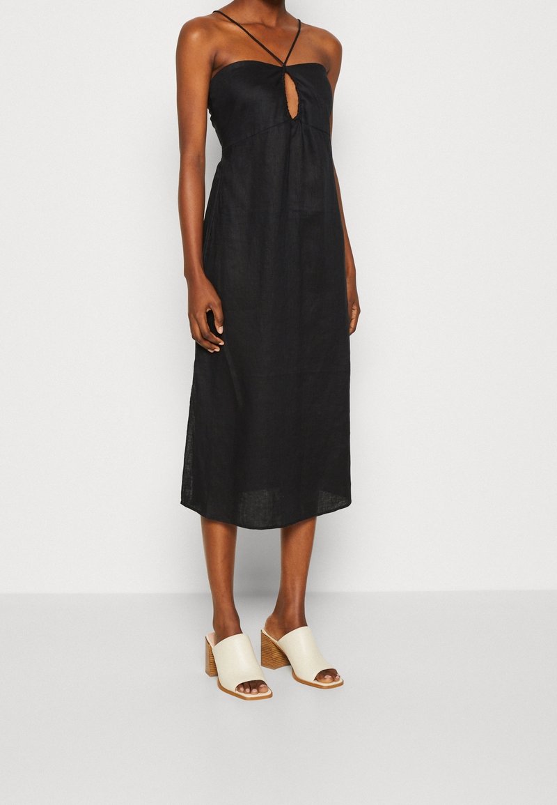Svart linn midi-klänning med en nyckelhålsklippning framtill och tunna axelremmar. Matchad med beige blockklackssandaletter med en texturerad yta.