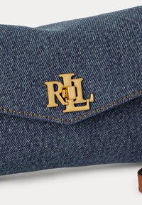 Μπλε τσάντα από τζιν με μεταλλικό λογότυπο «RLL» σε χρυσό τόνο και εμφανές καφέ δερμάτινο λουράκι.