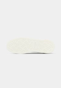 Λευκή λαστιχένια σόλα με υφή που διαθέτει μικρά λουλουδένια σχέδια. Ομαλή επιφάνεια και στρογγυλεμένο σχήμα, σχεδιασμένη για άνεση και πρόσφυση.