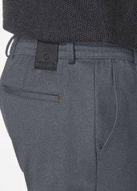 Gray trousers with a textured fabric, featuring a back pocket, orange stitching accent, and a black leather brand tag on the waistband.