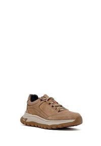 Zapatillas de ante en color marrón claro con suela de goma elevada, diseño de cordones y detalles en negro en el collar. Presenta un material texturizado y costuras reforzadas.