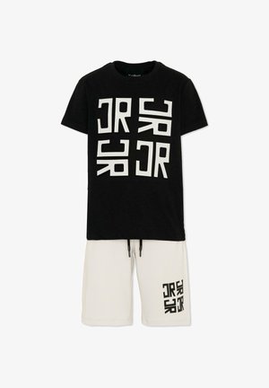 T-shirt nera a maniche corte con stampa del logo geometrico bianco abbinata a pantaloncini bianchi con coulisse con lo stesso logo sulla gamba sinistra.