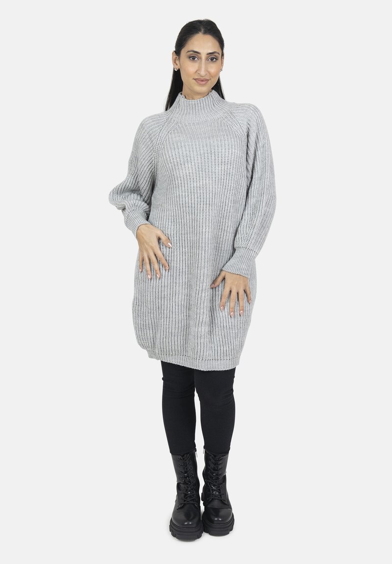 Grå strikket sweaterkjole med høj hals og lange ærmer, parret med sorte leggings og snørebånds combat boots.