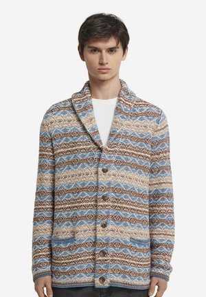 Strikket cardigan med et bølgemønster i brun, creme og blå, med en sjalkrave, knaplukning foran og to lommer.