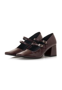 Scarpe con tacco in vernice bordeaux, con punta appuntita, due cinturini con fibbie argentate e tacco a blocco grande. Texture liscia e lucida.