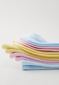 Hromada pletených ponožiek v pastelových farbách: modrá, ružová, žltá a krémová. Mäkká textúra, rebrovaný dizajn a zaoblené vrchy.