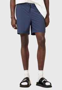 Meriveden uimashortsit, joissa on joustavyö ja nyöri. Valmistettu kevyestä kankaasta, jossa on sivutaskut ja rento istuvuus.