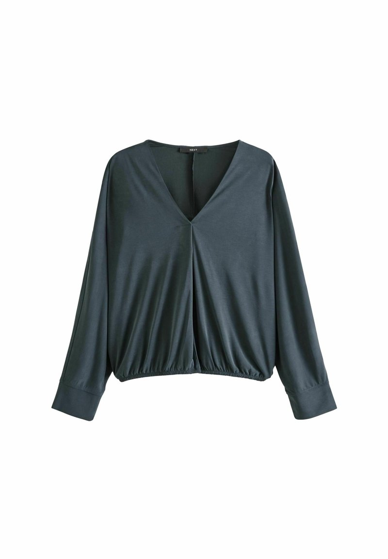 Blouse gris foncé à manches longues, col en V, taille élastique froncée et larges poignets, présentée sur un fond blanc.
