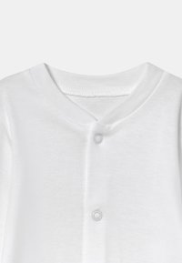 Camisa de algodón blanca con un diseño de cuello en V y dos botones a presión. Textura suave y diseño minimalista, adecuada para ropa casual.