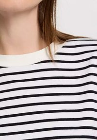 Czarny i biały t-shirt w paski z okrągłym dekoltem. Wykonany z miękkiej bawełny, z równomiernie rozłożonymi poziomymi paskami.