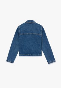 Chaqueta de mezclilla azul con un diseño recortado, mangas largas y un yugo trasero. Cuenta con costuras visibles y un dobladillo recto.