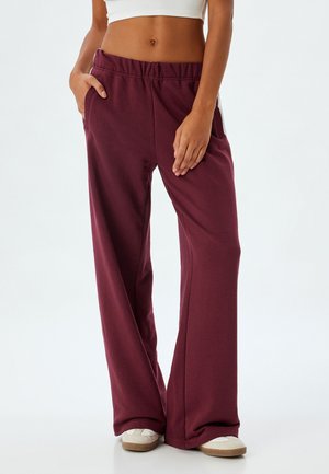 Bordeauxfarbene Sweatpants mit lockerer Passform, elastischem Bund und Seitentaschen. Aus weichem Stoff gefertigt, mit einem schlichten Design und strapazierfähiger Textur.