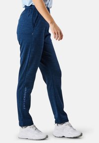 Marinblåa träningsbyxor i texturerat material, med en dragkedjeförsedd ficka och "SWEDEMOUNT"-logotyp tryckt på sidan.