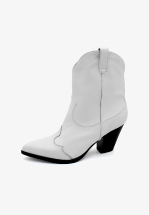 Hvide læder cowboystøvler med spids tå, buet syning og en kort sort blokhæl. Har en træksløjfe bagpå.