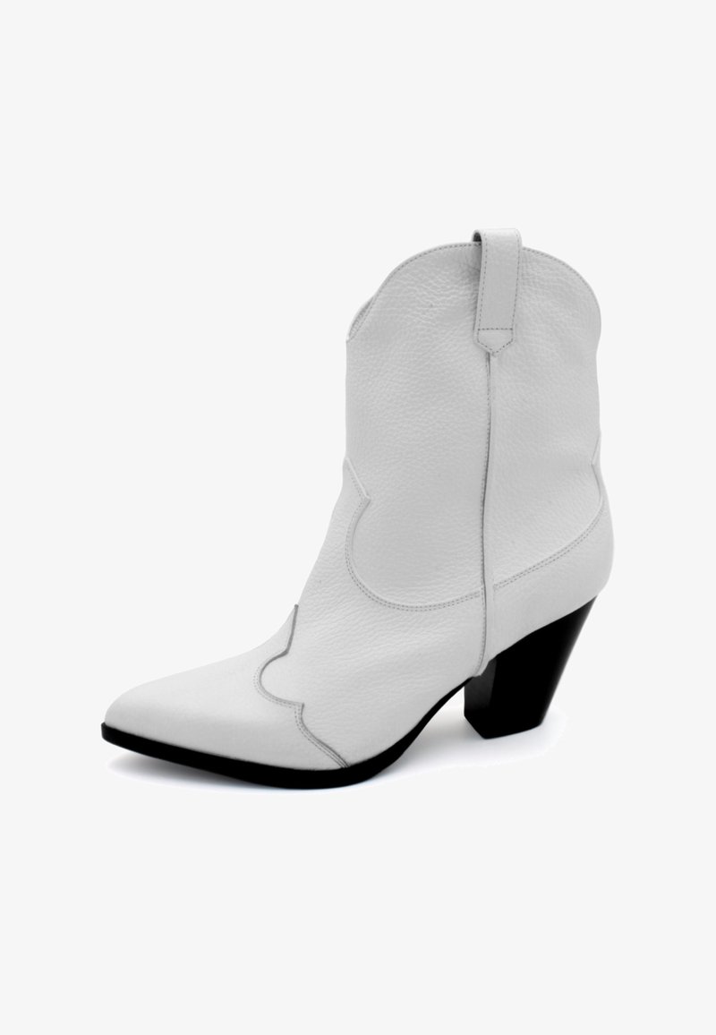 Baltas ādas kovboju zābaks ar norādītu purngalu, izliekumu adījumu detaļu un īsu melnu bloka papēdi. Tam ir cilpa aizmugurē.