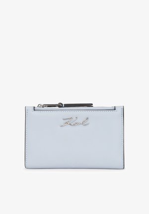 Jasnoniebieski skórzany portfel z srebrnym okuciem, z zamknięciem na zamek błyskawiczny oraz kursywnym logo 'Karl' z przodu. Kompaktowy, prostokątny kształt.